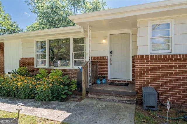 doorway to property featuring brick siding