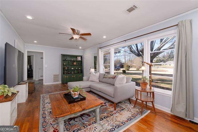 living room featuring crown molding, a ceiling fan, and visible vents