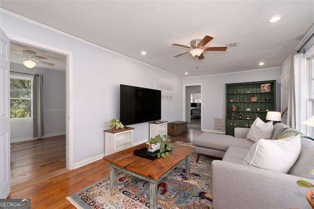 living room with visible vents, a ceiling fan, ornamental molding, and recessed lighting