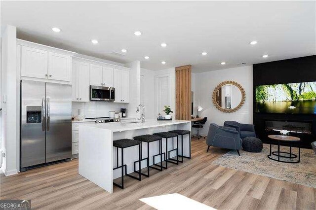4856 Allatoona Unit 8, Acworth, GA 30101 - kitchen with light wood finished floors, stainless steel appliances, a kitchen breakfast bar, and a sink