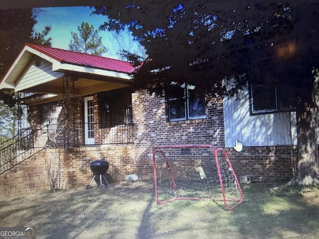 view of side of property with brick siding and metal roof