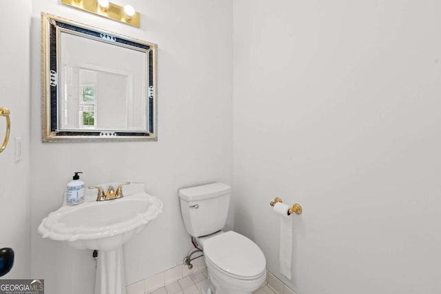 half bath with tile patterned floors and toilet