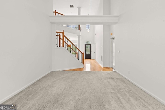 7020 Grand View Way, Suwanee, GA 30024 - carpeted foyer with decorative columns, stairs, and a towering ceiling