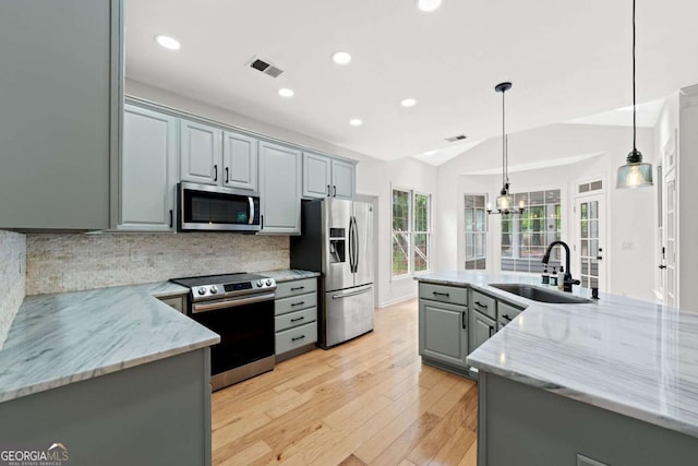 kitchen featuring a sink, stainless steel appliances, gray cabinets, visible vents, and light wood-style flooring