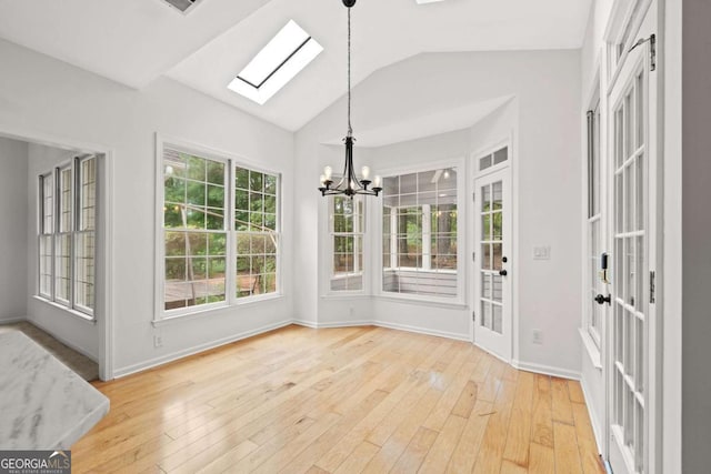 unfurnished sunroom with an inviting chandelier and a skylight
