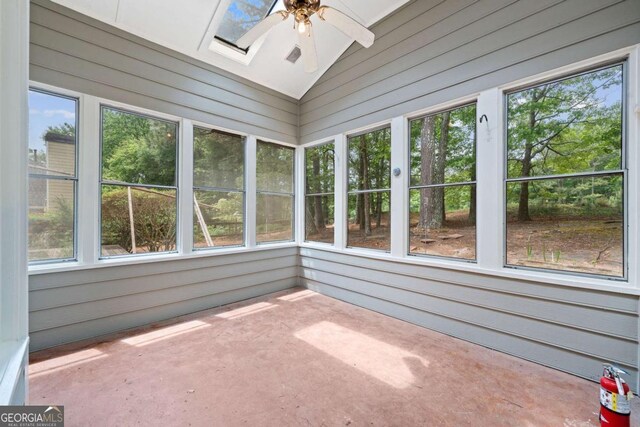 unfurnished sunroom with plenty of natural light, wood walls, and lofted ceiling with skylight