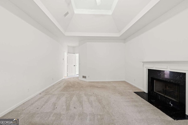 unfurnished living room featuring carpet flooring, a fireplace, a tray ceiling, and visible vents