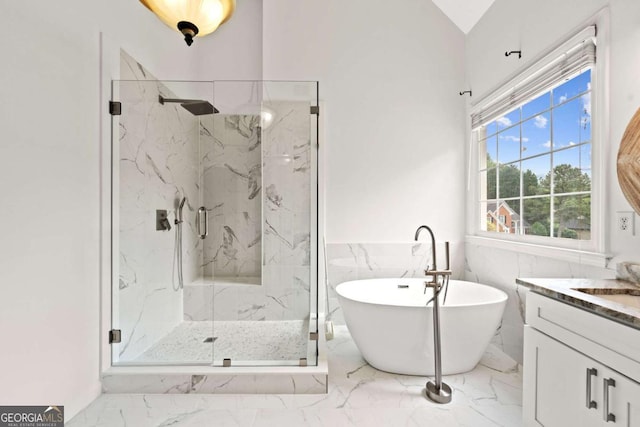 bathroom featuring a freestanding bath, a marble finish shower, marble finish floor, and vanity