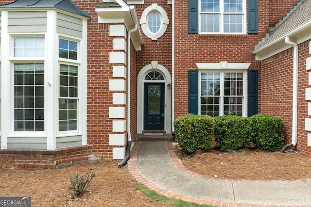 doorway to property with brick siding