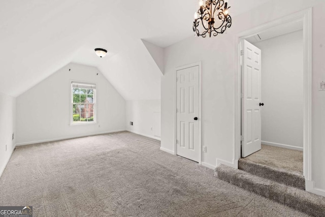 additional living space with baseboards, carpet flooring, and vaulted ceiling