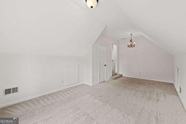 bonus room with baseboards, visible vents, vaulted ceiling, carpet flooring, and a notable chandelier
