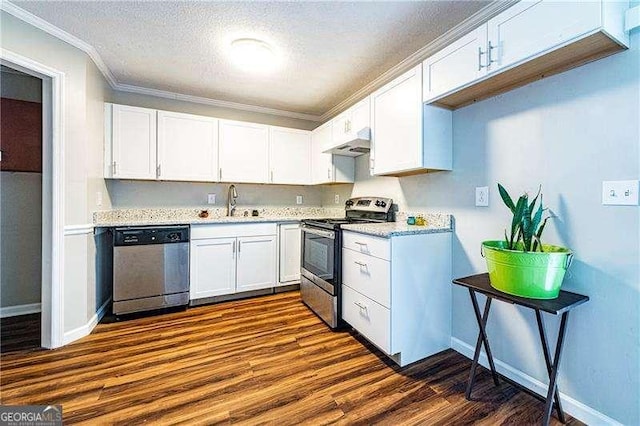 kitchen with under cabinet range hood, crown molding, dark wood-style flooring, baseboards, and appliances with stainless steel finishes
