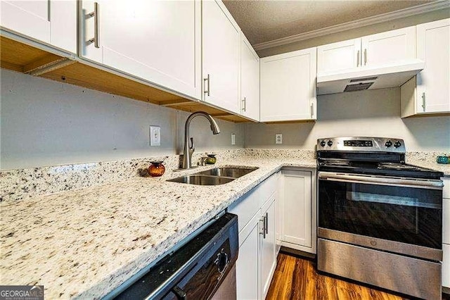 kitchen featuring under cabinet range hood, light stone counters, a sink, white cabinetry, and stainless steel appliances