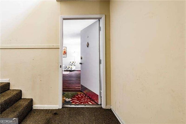 hall with stairway, carpet, and baseboards