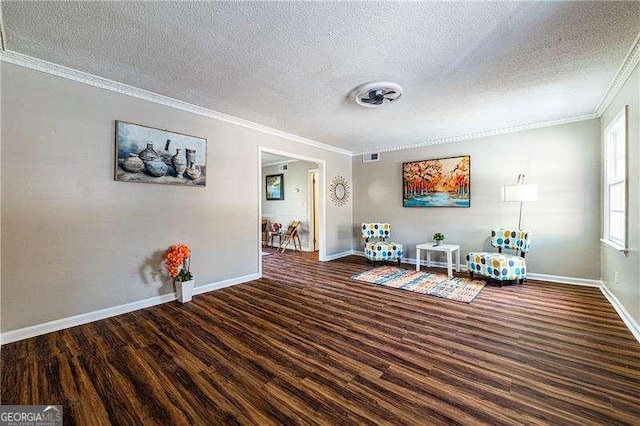 interior space with crown molding, a textured ceiling, wood finished floors, and baseboards