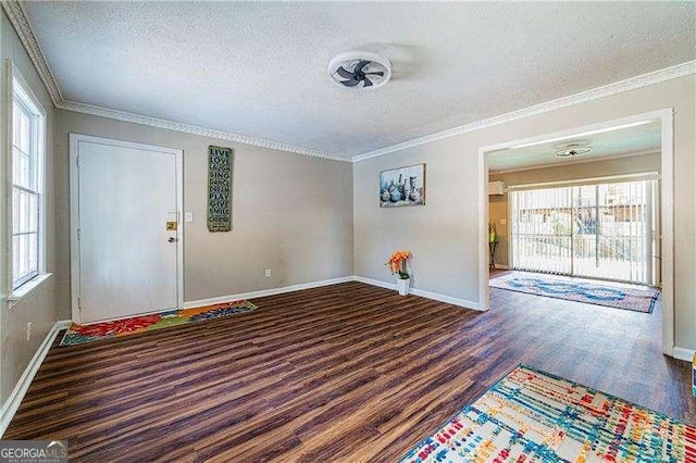 foyer entrance featuring a textured ceiling, a wealth of natural light, baseboards, and wood finished floors