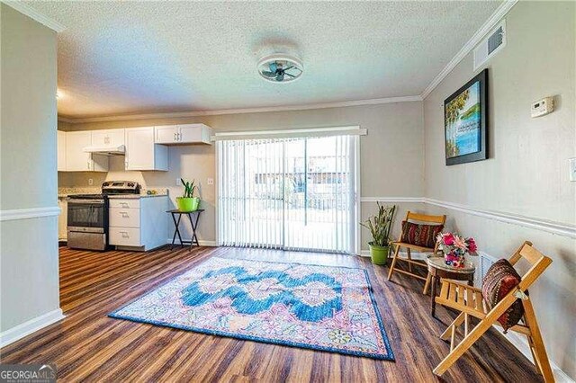 sitting room featuring ornamental molding, a textured ceiling, visible vents, dark wood-style floors, and baseboards