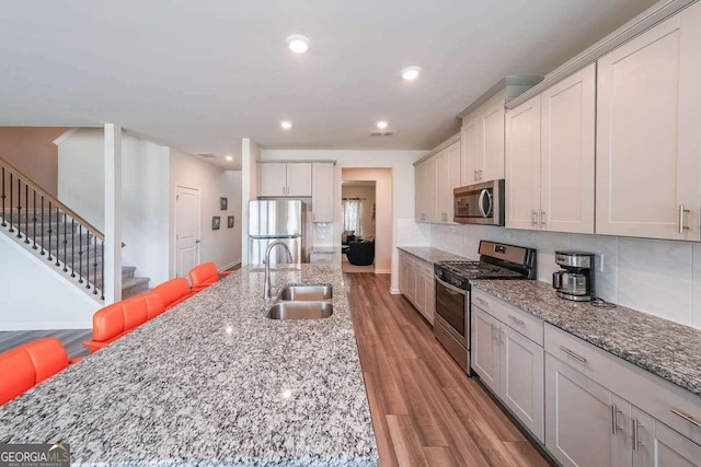 5958 Green Ash Ct, Braselton, GA 30517 - kitchen featuring stainless steel appliances, light wood-style floors, light stone countertops, recessed lighting, and decorative backsplash