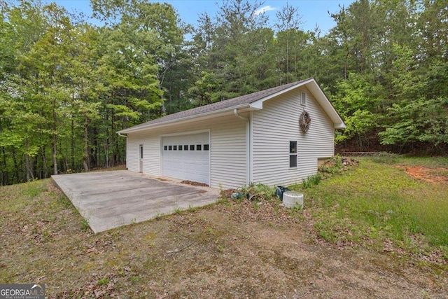 detached garage featuring a forest view