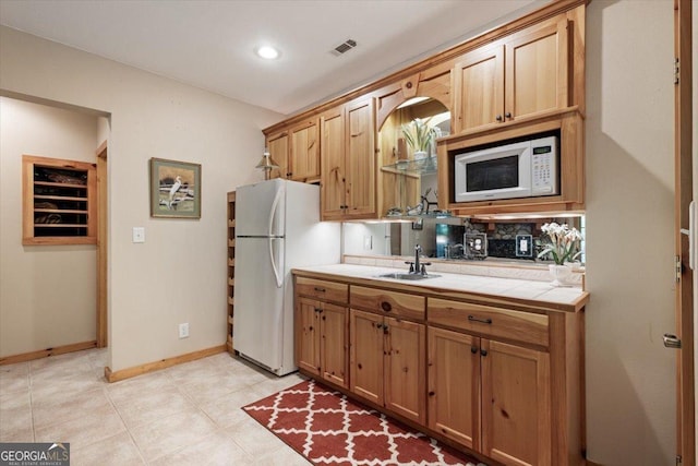 kitchen featuring a sink, visible vents, white appliances, tile countertops, and tasteful backsplash