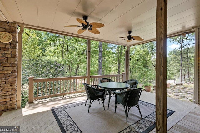 sunroom / solarium with outdoor dining area and ceiling fan