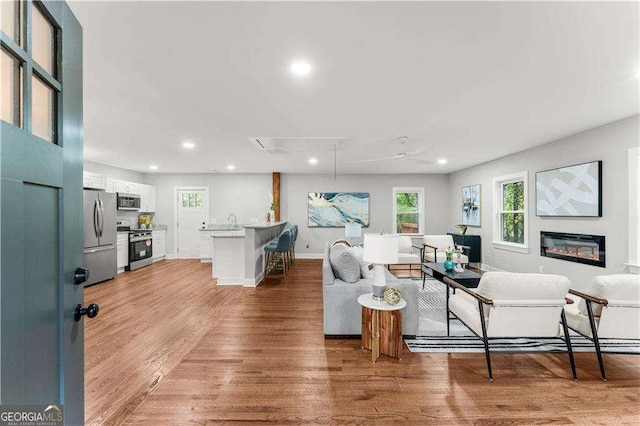 2205 Stockbridge Dr SE, Atlanta, GA 30316 - living area featuring light wood-style flooring, baseboards, a glass covered fireplace, and recessed lighting
