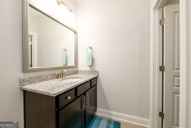bathroom with vanity, baseboards, and tile patterned flooring