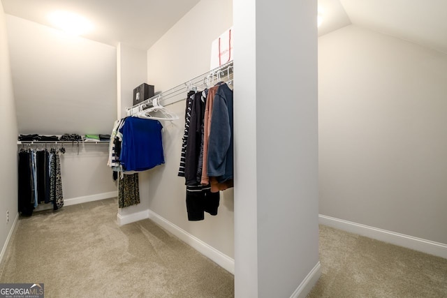 walk in closet featuring carpet flooring and vaulted ceiling