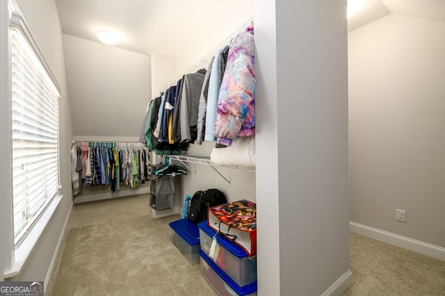 walk in closet with carpet flooring and vaulted ceiling