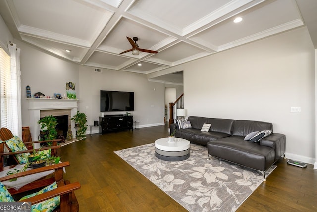 living area featuring a ceiling fan, wood finished floors, baseboards, coffered ceiling, and a fireplace