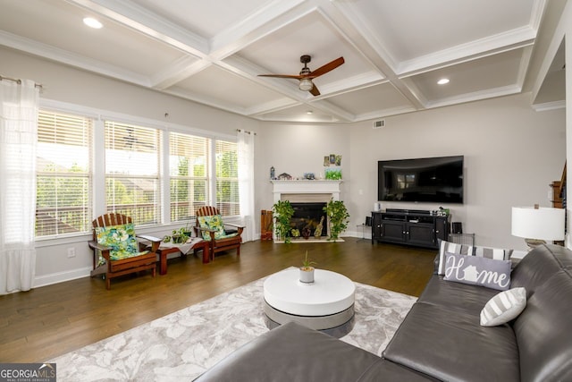 living room with a ceiling fan, wood finished floors, beamed ceiling, baseboards, and a fireplace
