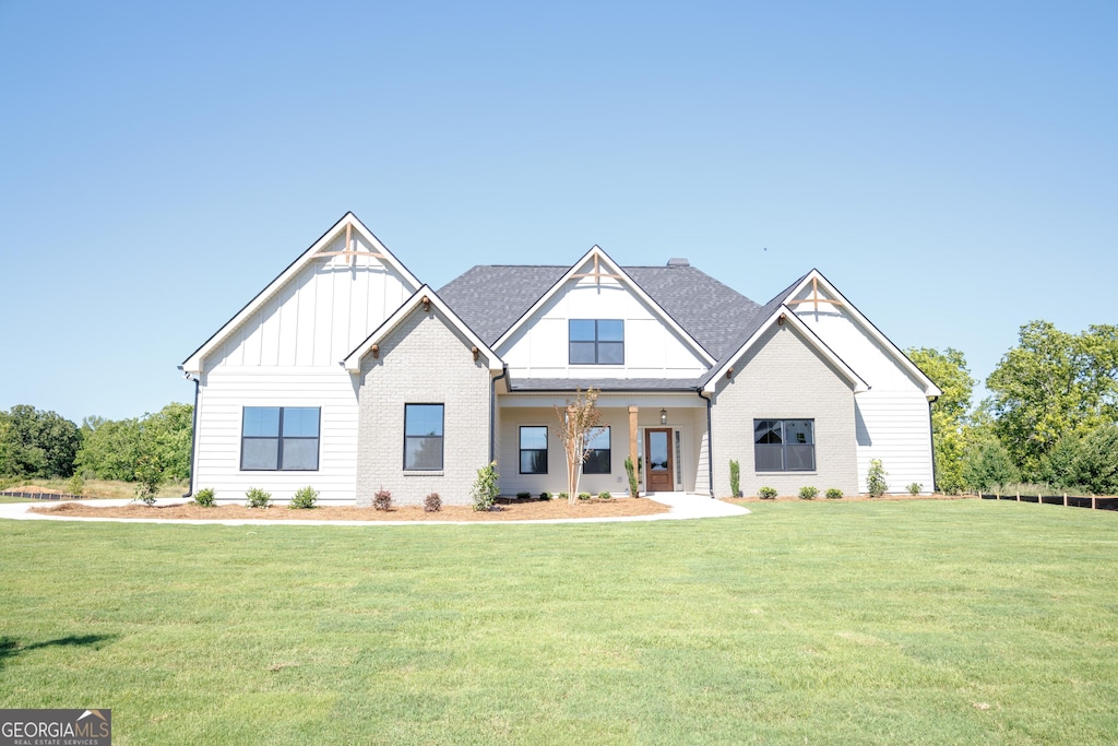 347 Grove Park Unit 86, Senoia, GA 30276 - view of front of home with board and batten siding, a front yard, and brick siding