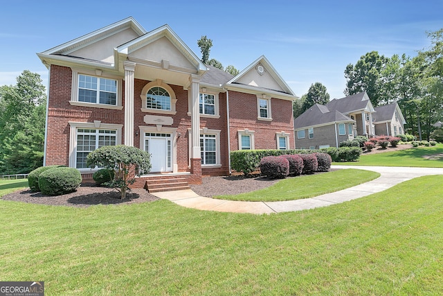 view of front of property featuring a front lawn and brick siding