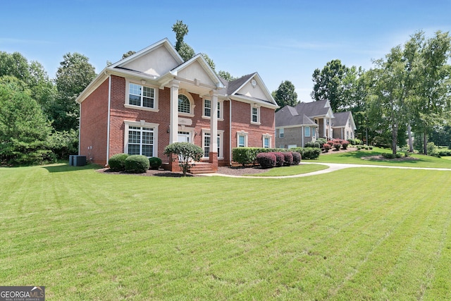 view of front of property with cooling unit, brick siding, and a front yard