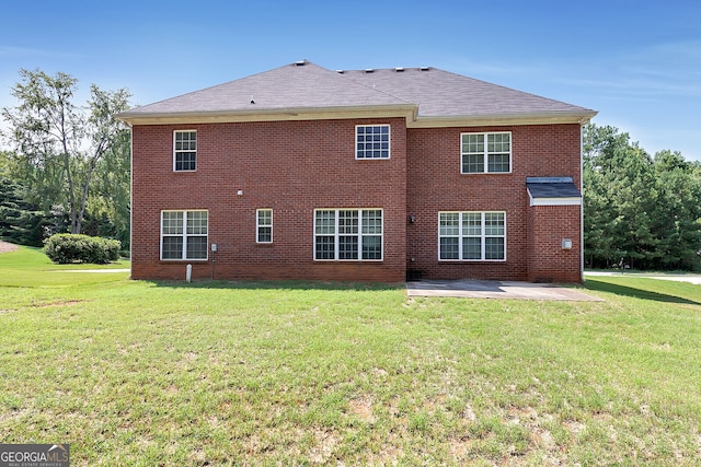 back of house with a patio, brick siding, and a lawn
