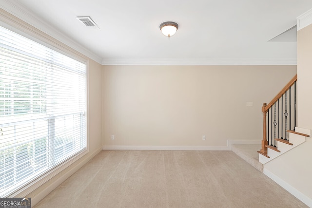 spare room featuring stairway, light carpet, ornamental molding, and baseboards