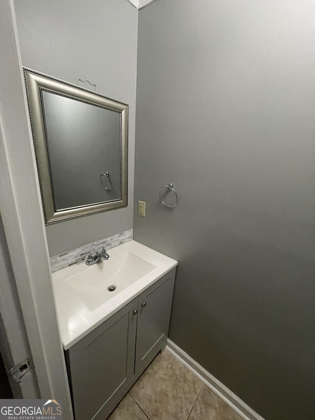 bathroom featuring baseboards, tile patterned flooring, and vanity