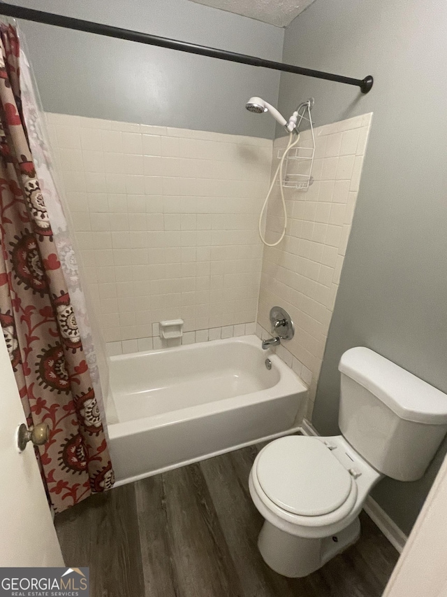 bathroom featuring shower / bathtub combination with curtain, wood finished floors, and toilet