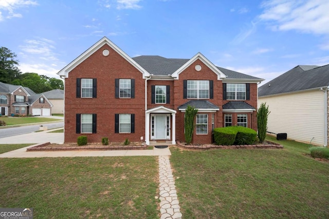 view of front of home with a front yard and brick siding