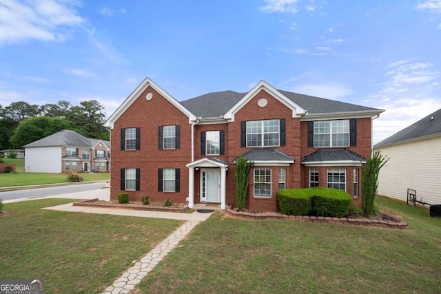 view of front of home with a front yard and brick siding
