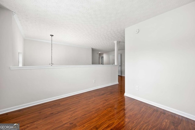 spare room with baseboards, a textured ceiling, and wood finished floors