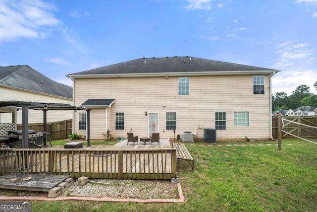 back of house with central AC unit, a deck, a lawn, and a fenced backyard