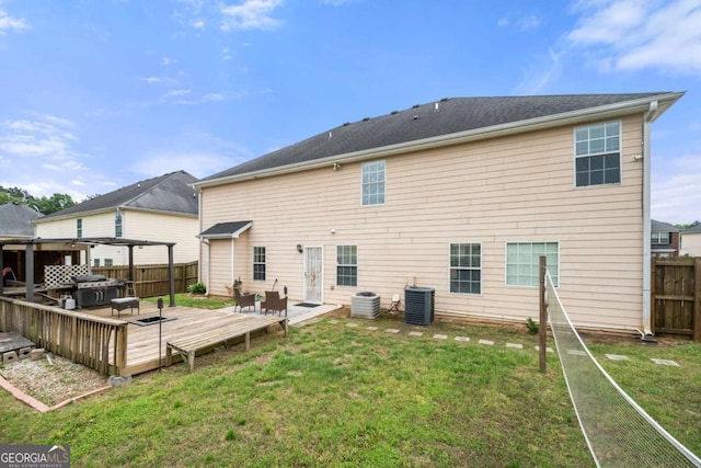 back of house with central AC, a wooden deck, a fenced backyard, and a lawn