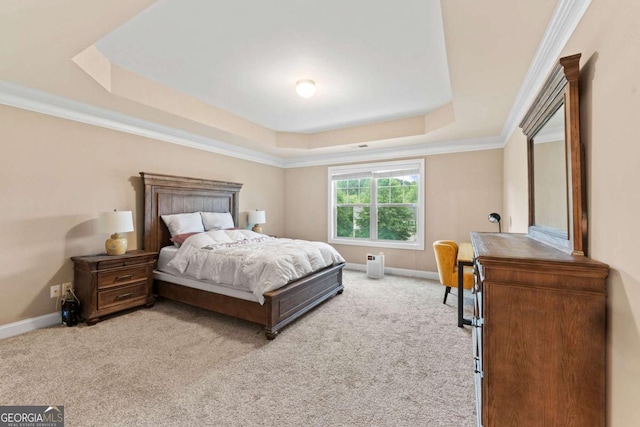carpeted bedroom with a tray ceiling, baseboards, and ornamental molding