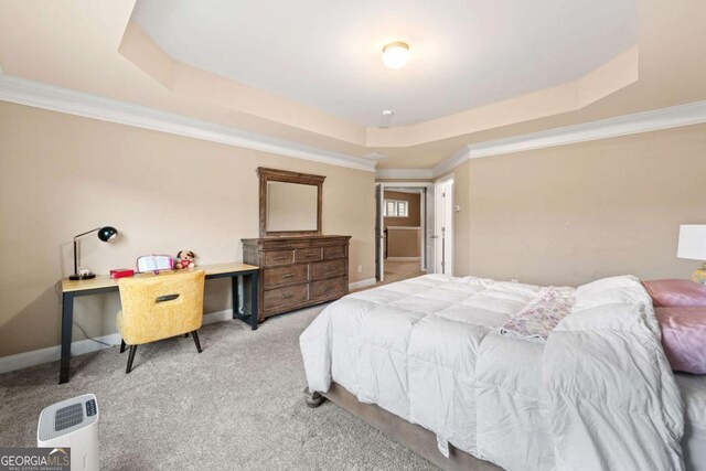 carpeted bedroom with baseboards, a raised ceiling, and crown molding