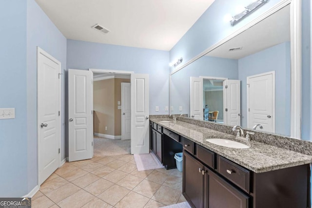 bathroom with a sink, double vanity, visible vents, and tile patterned floors