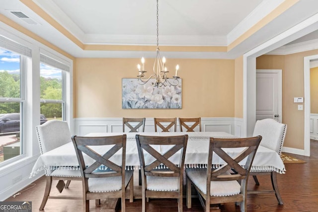dining room featuring crown molding, an inviting chandelier, visible vents, and a decorative wall