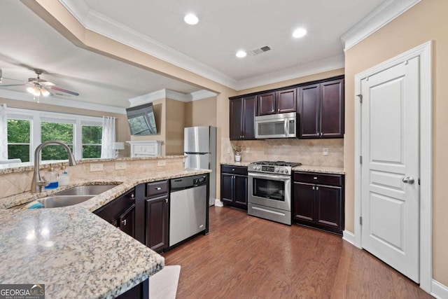 kitchen with a sink, stainless steel appliances, visible vents, ceiling fan, and backsplash