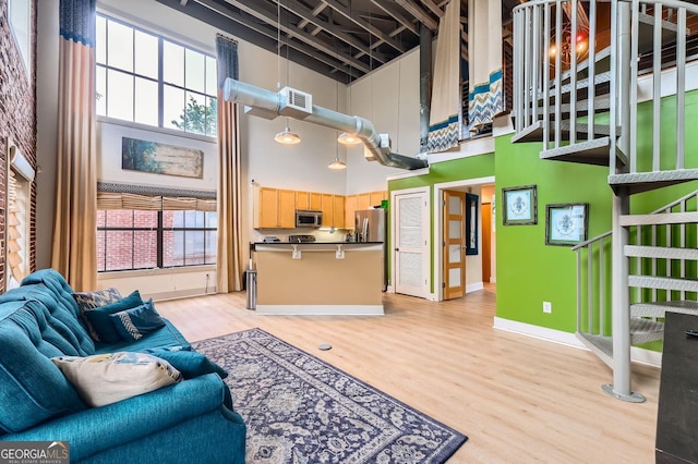 791 Wylie St SE Unit 410, Atlanta, GA 30316 - living room with a high ceiling, light wood-style flooring, and baseboards