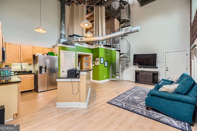 791 Wylie St SE Unit 410, Atlanta, GA 30316 - kitchen featuring stainless steel refrigerator with ice dispenser, a high ceiling, dark countertops, open floor plan, and light wood finished floors